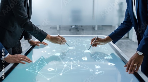 Business team collaborating on digital strategy using interactive smart table, network connection analysis, corporate planning meeting with executives discussing future growth