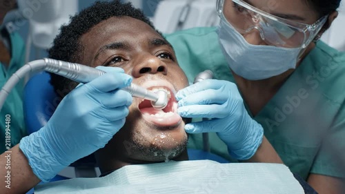 Dentist Performing Dental Work on Patient's Teeth, Close-Up