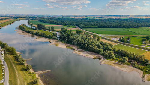 Ein Fluss schlängelt sich durch eine grüne Landschaft mit Bäumen und Wiesen