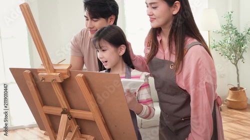 Girl Enjoys Painting With Parents at Home During a Family Activity