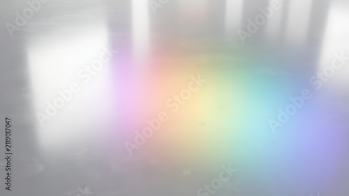 Abstract background with soft rainbow light reflections on a smooth grey surface.