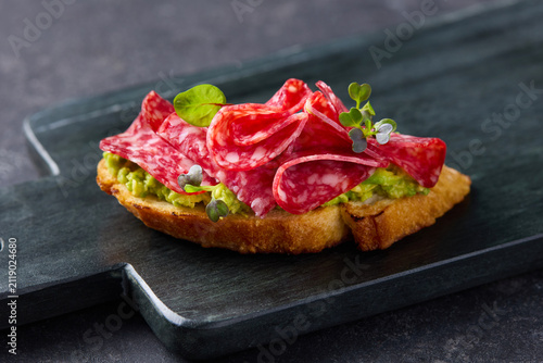 Traditional spanish tapas with cured salami meat fresh vegetables and green herbs side view. Close up.