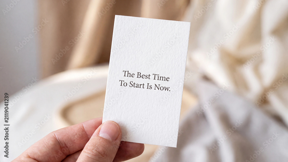 Fototapeta premium Hand holding a small white card with the inspirational quote the best time to start is now written on it