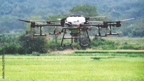 Agricultural Drone Spraying Crops Over Green Farm Field
