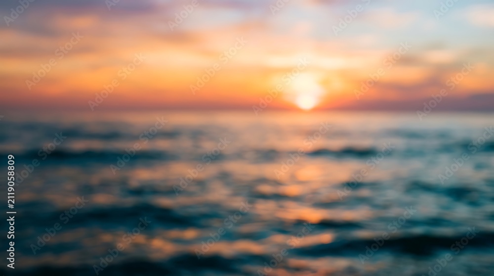 Fototapeta premium A beautiful golden sunset over the calm ocean waves creating a peaceful and serene atmosphere during the late evening summer time