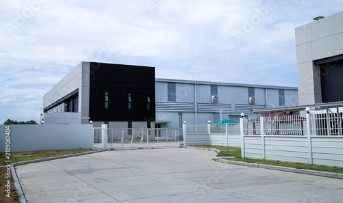 Принти на полотні Modern factory building exterior with office area and parking lot in industrial