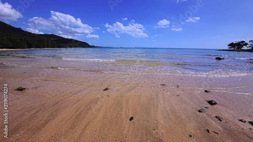 Transparent shallow seawater washing over smooth tropical beach sand