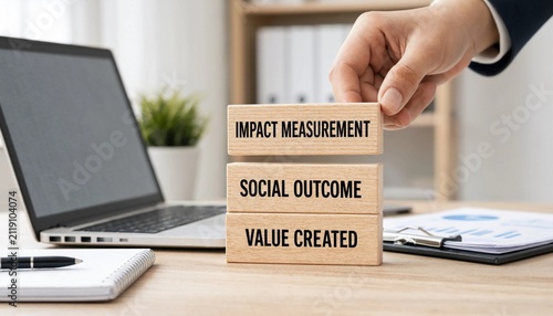 Professional stacking wooden blocks showing impact measurement social outcome and value created on office desk