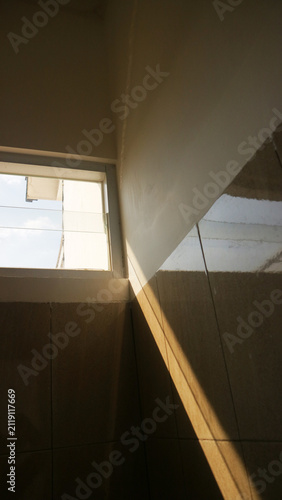 Sunlight Streaming Through Bathroom Window Creating Dramatic Shadows