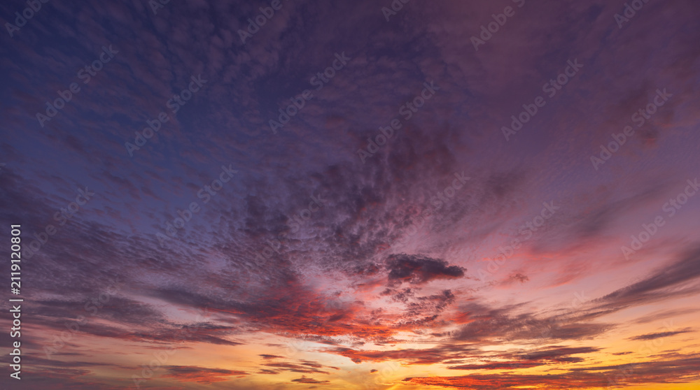 Fototapeta premium Vibrant Purple and Orange Sunset Sky with Textured Clouds,A breathtaking view of a dramatic sunset sky filled with vibrant purple, blue, and fiery orange clouds, creating a stunning colorful backgroun