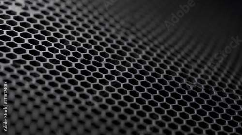 Metallic black honeycomb grid pattern with depth of field