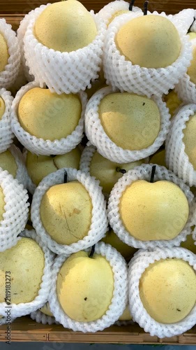 Fresh pears wrapped in protective foam. The pears are neatly arranged for display. 