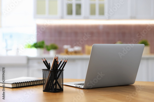 Comfortable workplace with laptop on wooden table indoors, closeup