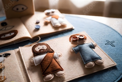 Jesus healed and restored sight to the blind as a soft quiet-book activity page for young children with fabric figures and simple movable elements, the environment a peaceful learning nook with felt p