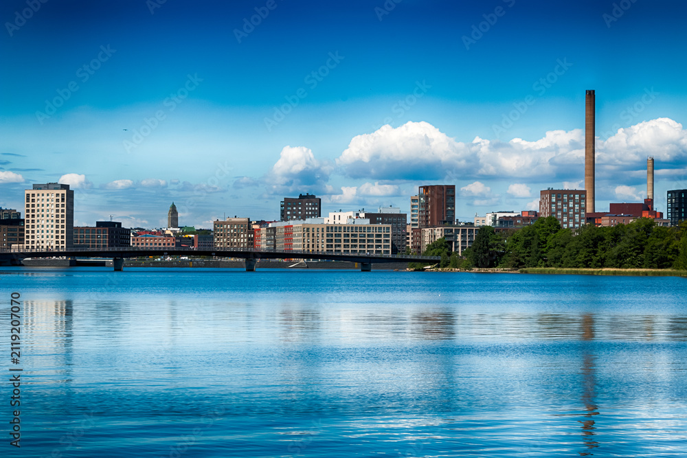 Obraz premium Modern residential buildings in the Sompasaari district viewed across the water from Mustikkamaa island in Helsinki, Finland, on a sunny, cloudless summer day. HDR.