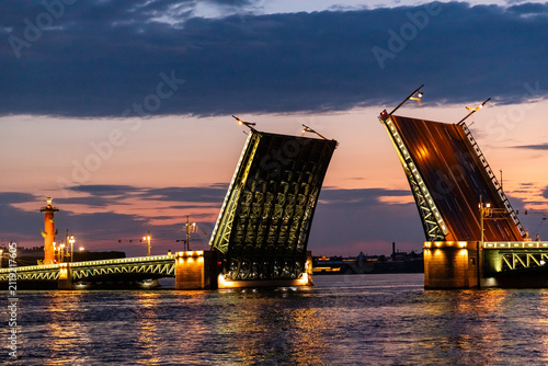 Foto Illuminated Palace Drawbridge opens during white nights over Neva river, engineering architecture in cityscape