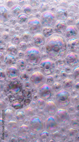 Macro background of iridescent soap bubbles with rainbow colors and foam texture