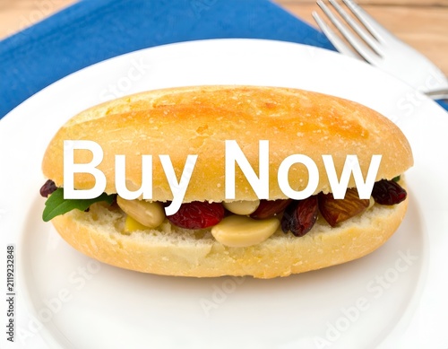 Miniature bread bun sandwich filled with nuts and berries on white plate