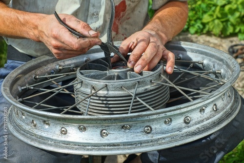 Konstfotografi Close-up of a mechanic removing a retaining snap ring from a motorcycle wheel hub using circlip pliers during bearing replacement