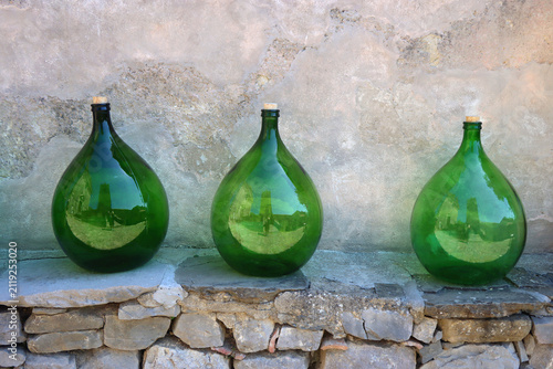 фотографія Traditional round glass bottles displayed on the Mediterranean street