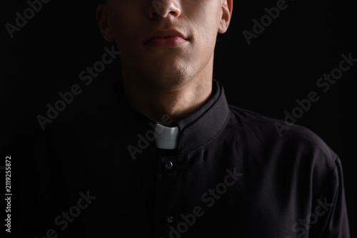 фотографія Priest in cassock on black background, closeup