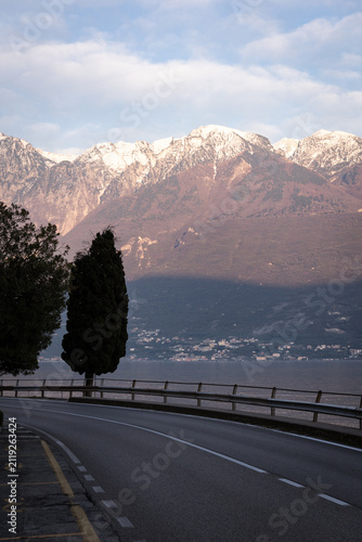 Scenic Road Along Lake Garda with Snow-Capped Mountains at Sunset, Italy