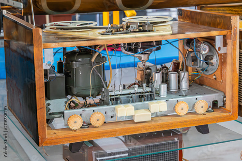 Vintage electronic device internal components display, featuring intricate mechanical and electrical parts, well-preserved condition, close-up shot with elevated perspective, bright even lighting