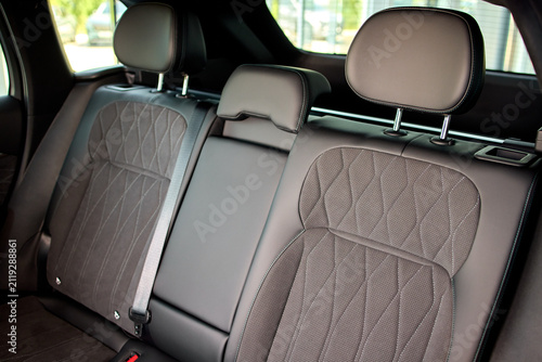 Konstfotografi Rear leather car seats with center armrest, three headrests, visible seatbelt bu