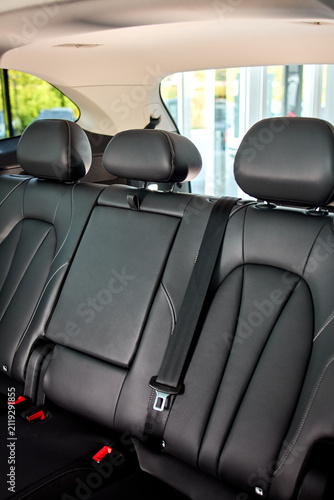 Bild auf Leinwand Rear leather car seats with center armrest, three headrests, visible seatbelt bu