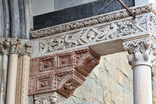 Close-up of architectural details of a historic church in Bergamo. Natural sunlight highlights the carved stone, craftsmanship and rich texture of the sacred architecture, showcasing Italian artistic 