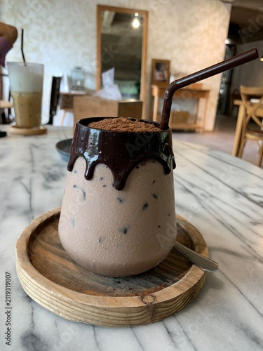 Obraz na plátně Iced chocolate glass topped with cocoa powder and decadent chocolate syrup drip down the sides