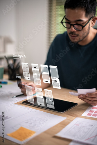 A male designer working on website prototype, in UX UI concept design and development for a website and mobile app prototype, with hologram interface