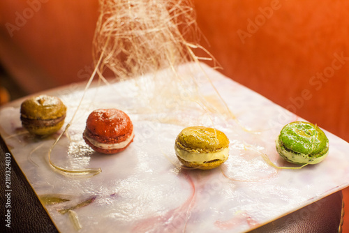 Photography Assorted sweet macarons decorated with delicate spun sugar threads against a war