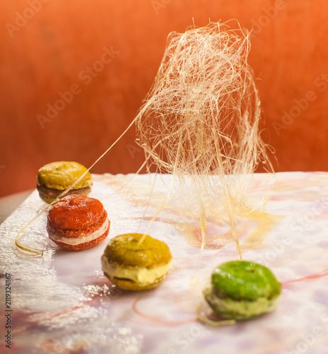 Canvastavla Fine dining dessert featuring colorful macarons and a spun sugar dome sculpture
