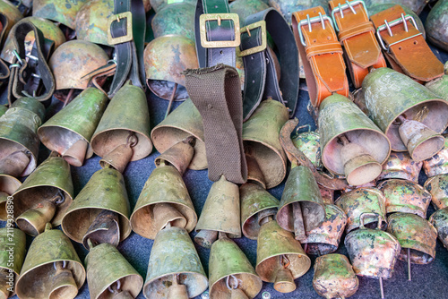 Brass bells for sale at an outdoor market.