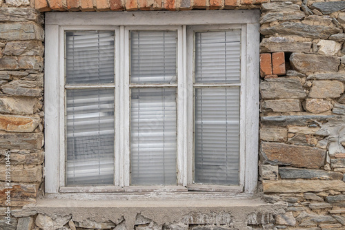 Window in a rough cut stone house.