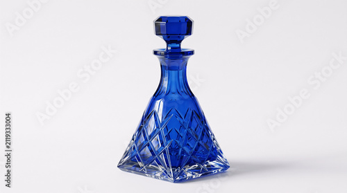 Blue glass decanter on white background. Elegant crystal bottle for spirits or liquor.