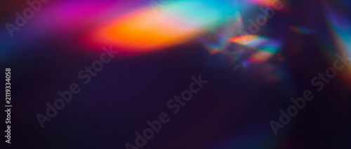 Prism light leak overlay on dark background with vibrant neon rainbow bokeh refractions, crystal spectrum lens flare, and soft blurred gradients for creative abstract design