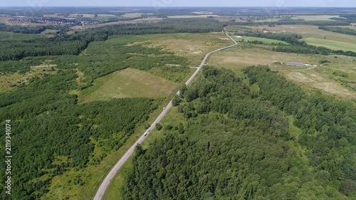 Drone flying forward and down over forest road
