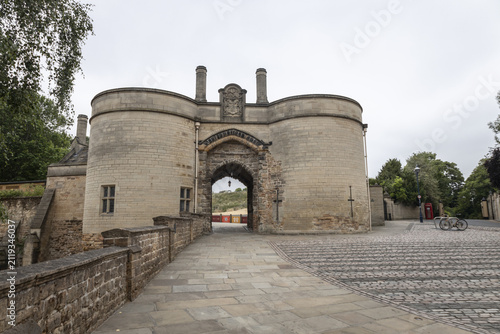 View of the historic gatehouse of Nottingham Castle with its stone towers and arched entrance on a cobblestone path in Nottingham, England, United Kingdom.