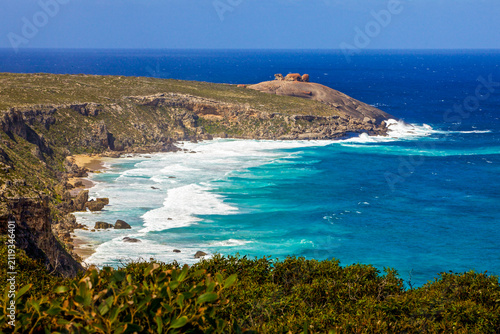 Картината върху платно The rugged coastline features dramatic cliffs overlooking a brilliant turquoise sea with crashing white waves