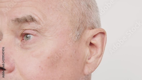 bald man hearing or listening deeply, ear with pained expression, discomfort loud noise, age-related hearing loss, Emotional portrait, discomfort loud noise, Environmental noise, reaction loud sounds