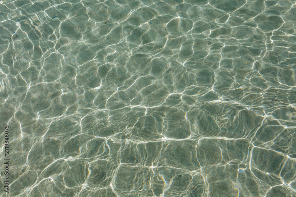 Fototapeta premium Crystal Clear Seawater with Sunlight Reflections and Gentle Ripples