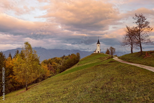 St.Primus and Felician hilltop Gothic church on a grassy ridge backed by the Karavanke mountains, on a cloudy autumn afternoon. Jamnik-Slovenia-176