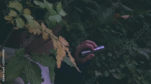 Young person with LED torch in darkness, exploring unknown and symbolizing mystery and survival, Teenager with flashlight in dark, searching for way out, night danger, young explorer