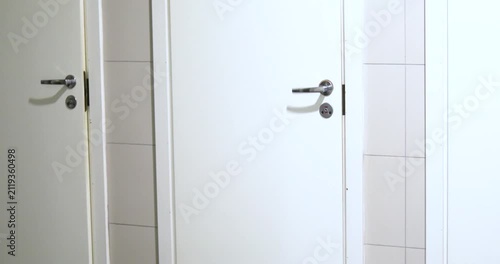 Closing the door to a public restroom stall.