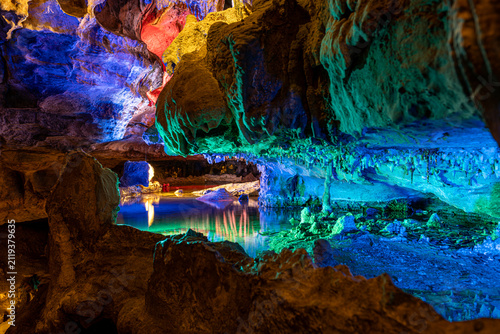 Foto Wide angle view of an illuminated underground cave with colorful light reflectio