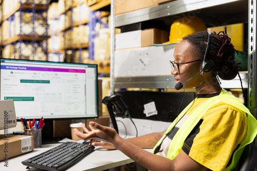 фотографія An African American woman answers calls from people in a logistics hub, handling order mix-up problems and requests via customer service helpline