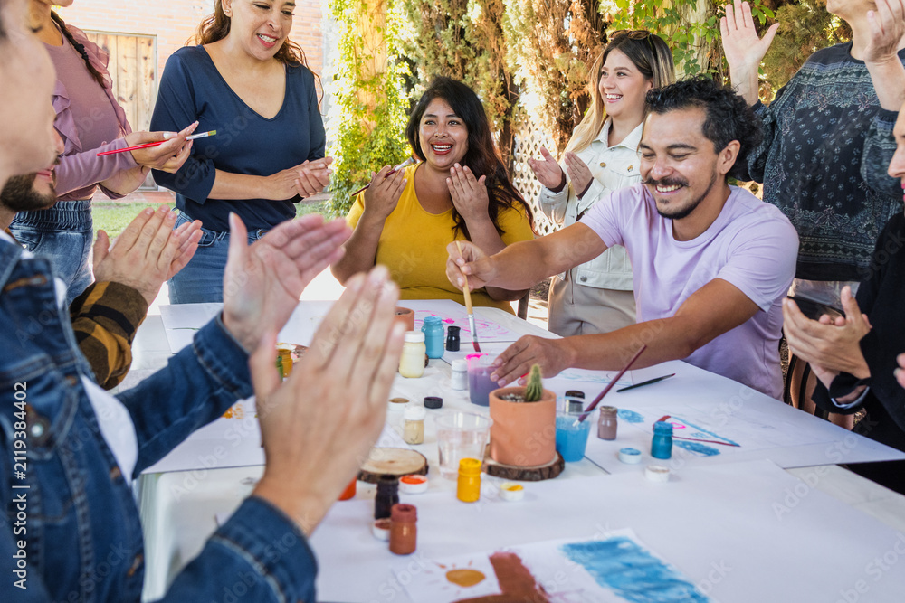 Obraz premium large group of latin people in painting classes in a terrace outdoors in Mexico Latin America, multi generational Hispanic and diverse team meeting in art classes 