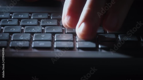 Close-up timelapse male hands typing rapidly on keyboard with motion blur, camera smoothly slides parallel to keys. Dynamic footage of remote work, business activity and digital workflow at night
